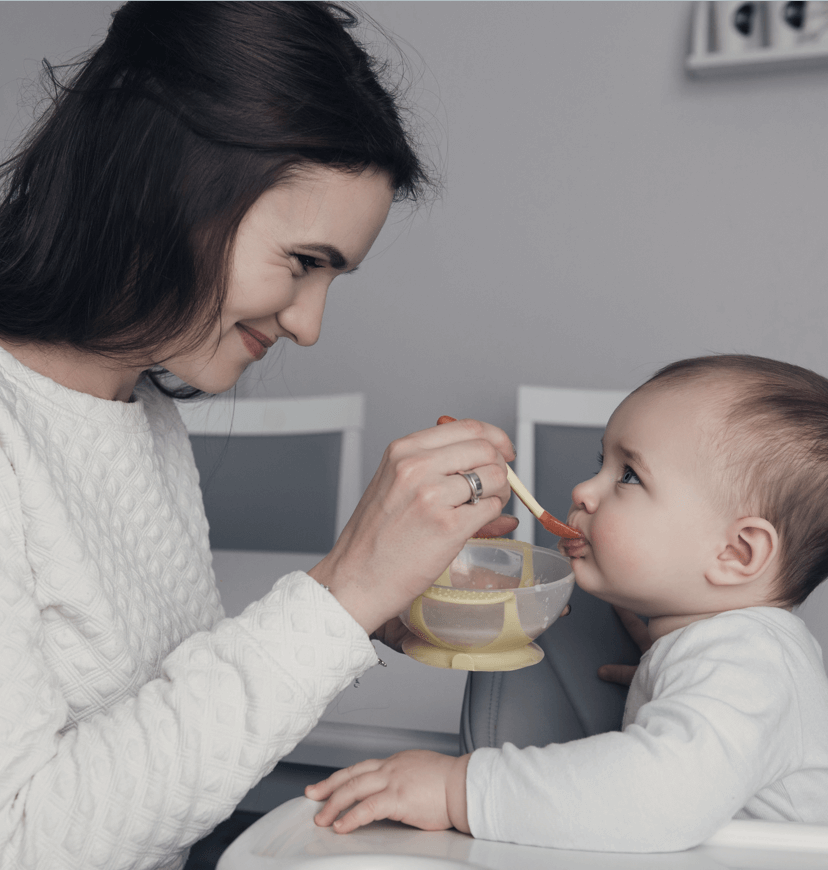 Madre feliz alimentando a su bebé conoce más sobre los productos Gerber