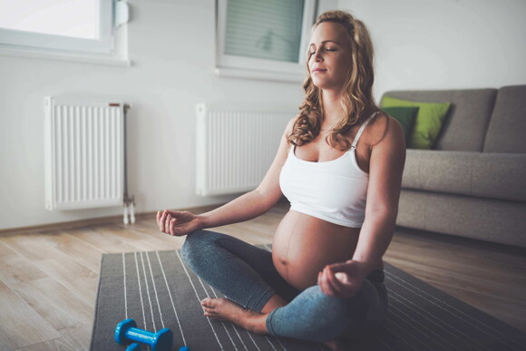 Mujer embarazada sentada meditando